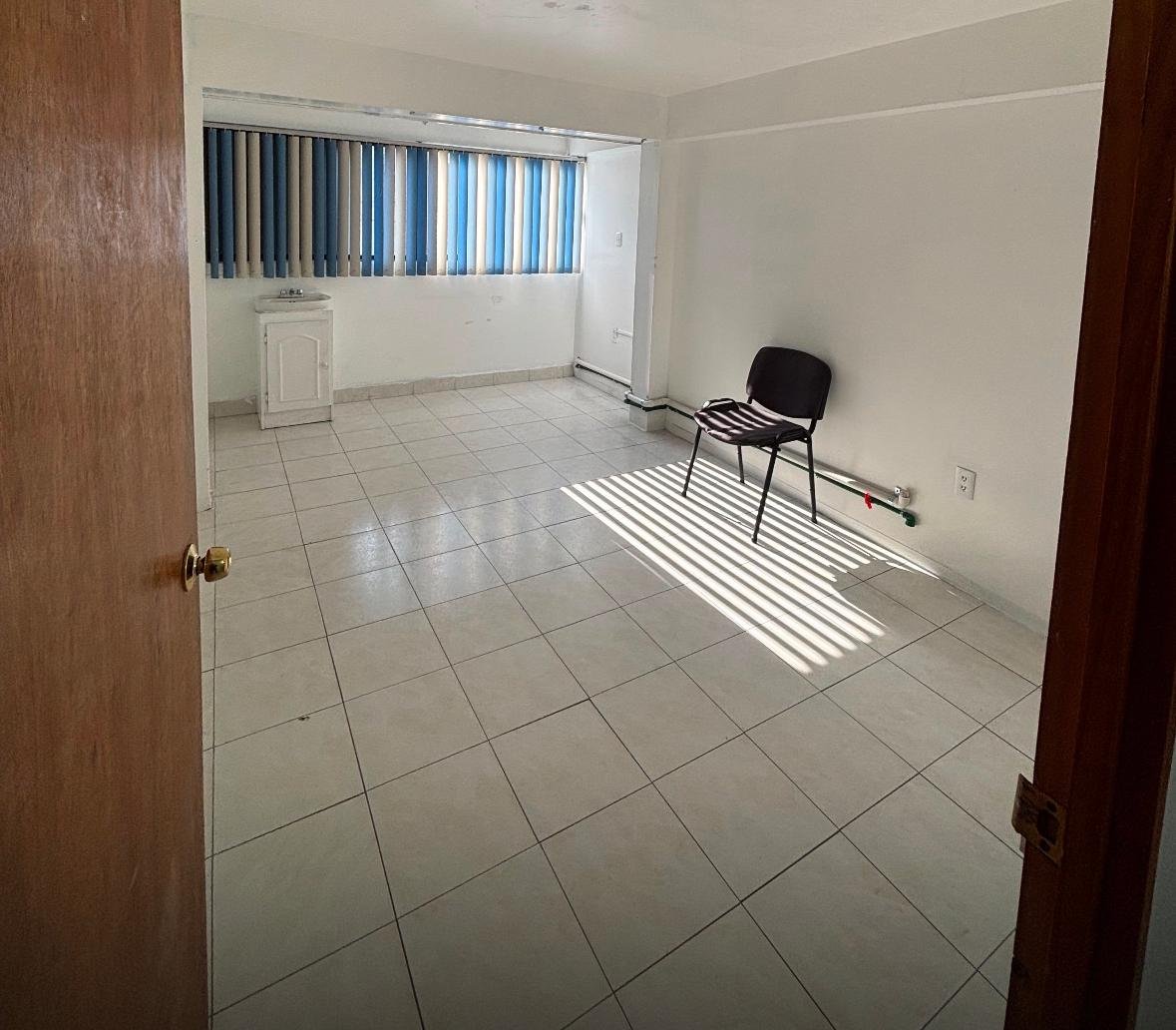 Consultorio amplio con lavabo y persianas