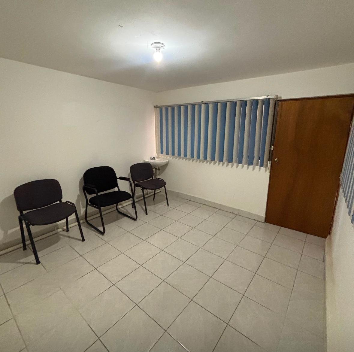 Consultorio con persianas, lavabo y área de atención